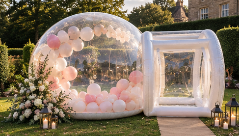 The Bubble set up outdoors for a wedding with blush pink and white balloons and floral arrangements