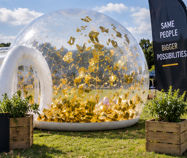 The Bubble filled with swirling gold foil slips at a corporate outdoor event