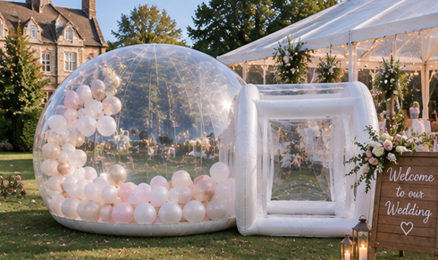 The Bubble set up for a wedding with blush pink and white balloons beside a marquee